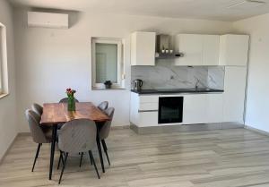 a kitchen and dining room with a table and chairs at LARUS apartment in Kastel Luksic
