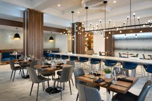 a restaurant with tables and chairs and a bar at Marriott Jacksonville in Jacksonville