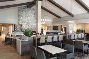 a restaurant with tables and chairs and a stone wall at Residence Inn by Marriott Orlando at SeaWorld in Orlando