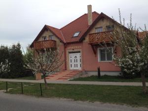 une maison avec un toit rouge et une porte blanche dans l'établissement Regina Apartman Hegykő, à Hegykő