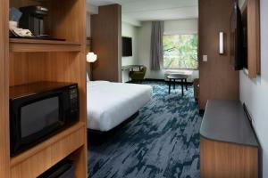 a hotel room with a bed and a tv at Fairfield by Marriott Inn & Suites Memphis Arlington in Arlington