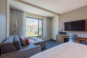 a hotel room with a couch and a flat screen tv at Courtyard by Marriott Thousand Oaks Agoura Hills in Agoura Hills