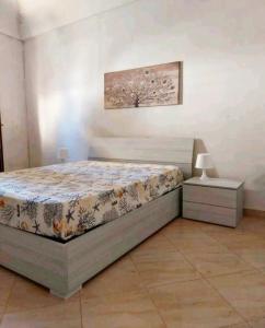 1 dormitorio con 1 cama, 1 mesa y 1 foto en Casa Ortigia, en Siracusa