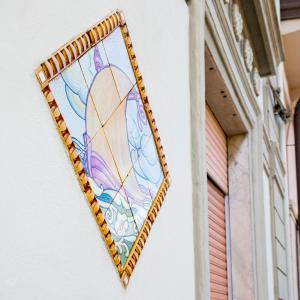 a mosaic picture of a sailboat on a wall at Hotel Paolina in Viareggio