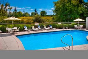 a swimming pool with chairs and umbrellas at Fairfield Inn Portsmouth Seacoast in Portsmouth