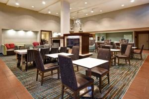um restaurante com mesas e cadeiras e uma lareira em Residence Inn by Marriott Stillwater em Stillwater