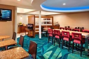 a dining room with red chairs and tables at SpringHill Suites Victorville Hesperia in Hesperia