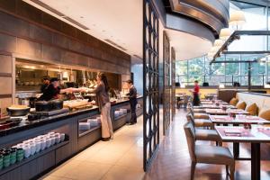 een restaurant met tafels en een chef-kok die maaltijden bereidt bij Tokyo Marriott Hotel in Tokyo