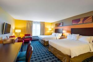 a hotel room with two beds and a desk at TownePlace Suites by Marriott Kansas City Overland Park in Overland Park