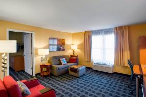 a hotel room with a couch and a chair at TownePlace Suites by Marriott Kansas City Overland Park in Overland Park