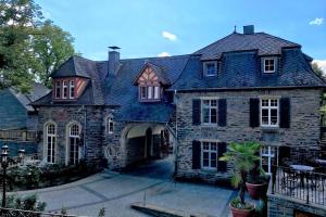 a large stone house with a black roof at Schloss Lieser, Autograph Collection in Lieser