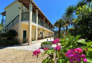 una casa con fiori rosa di fronte di Ionian Escape Seaview Apartments a Mesongi