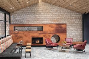 a lobby with a fireplace and red chairs at SpringHill Suites by Marriott New York Manhattan/Times Square South in New York