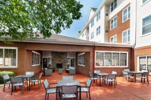 a patio with tables and chairs in front of a building at Residence Inn Potomac Mills Woodbridge in Woodbridge
