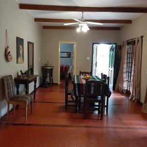 uma sala de jantar com uma mesa e cadeiras e uma ventoinha de tecto em Casa Principal - El Bamboo Eventos em Arturo SeguÃ­