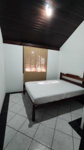a bed in a room with a ceiling at Cabelera's House in Bombinhas