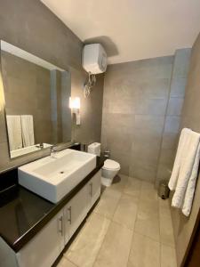 a bathroom with a white sink and a toilet at Beach Paradise Nilaveli in Trincomalee