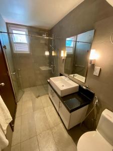 La salle de bains est pourvue d'un lavabo, d'une douche et de toilettes. dans l'établissement Beach Paradise Nilaveli, à Trincomalee
