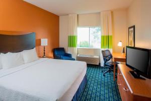 a hotel room with a bed and a flat screen tv at Fairfield Inn Middletown Monroe in Middletown