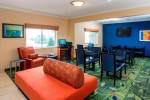 a waiting room with an orange couch and chairs at Fairfield Inn Middletown Monroe in Middletown