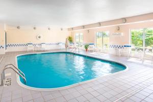 uma grande piscina num quarto de hotel com cadeiras e uma mesa em Fairfield Inn Middletown Monroe em Middletown