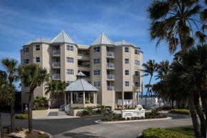 un gran edificio de apartamentos con palmeras y cenador en Marriott Hutchinson Island Beach Resort, Golf & Marina, en Stuart
