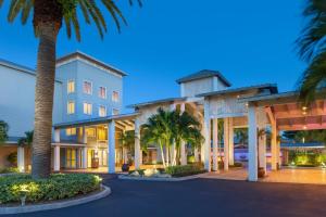 a large building with palm trees in front of it at Marriott Hutchinson Island Beach Resort, Golf & Marina in Stuart