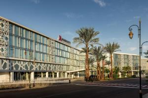 um edifício com palmeiras em frente a uma rua em Rabat Marriott Hotel em Rabat
