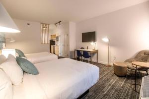 コンローにあるTownePlace Suites by Marriott Conroeのベッド、デスク、椅子が備わるホテルルームです。