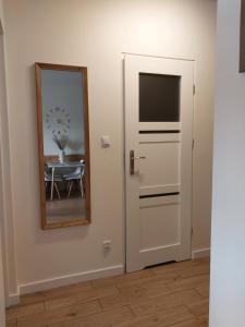 a door with a mirror next to a table with a dining room at Telimena in Wyszków