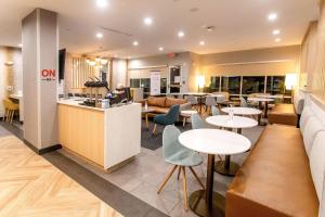 a restaurant with tables and chairs and a bar at TownePlace Suites by Marriott Conroe in Conroe