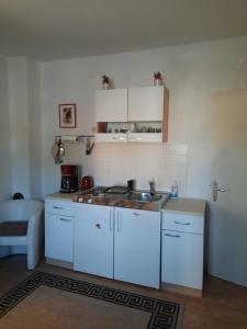 kuchnia z białymi szafkami i zlewem w obiekcie Studio Apartment Katalpa w mieście Zadar