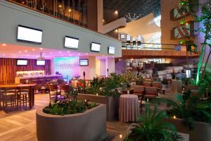 un restaurant avec des tables, des chaises et des plantes dans l'établissement Marriott Tuxtla Gutierrez Hotel, à Tuxtla Gutiérrez