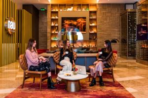 Tres mujeres sentadas en sillas en un vestíbulo en Medellin Marriott Hotel en Medellín