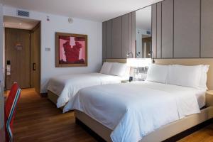 a hotel room with two beds and a mirror at Medellin Marriott Hotel in Medellín