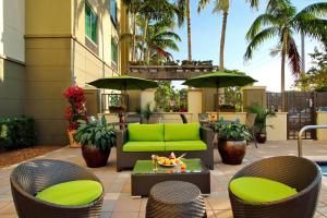 un patio con un sofá verde, sillas y una mesa en Fairfield Inn & Suites Fort Lauderdale Airport & Cruise Port, en Dania Beach