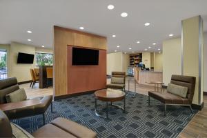 a waiting room with chairs and a flat screen tv at TownePlace Suites by Marriott Grand Rapids Wyoming in Wyoming