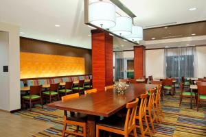 un comedor con una gran mesa de madera y sillas en Fairfield Inn & Suites Fort Lauderdale Airport & Cruise Port, en Dania Beach
