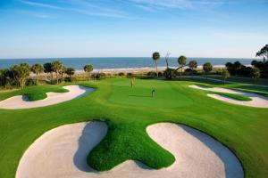 a view of a golf course with the ocean in the background at Hilton Beachfront Resort & Spa Hilton Head Island in Hilton Head Island