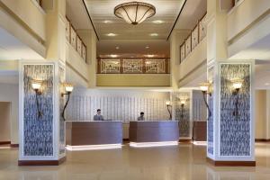 a lobby of a hotel with two people at the reception desks at Hilton Beachfront Resort & Spa Hilton Head Island in Hilton Head Island +81 photos
