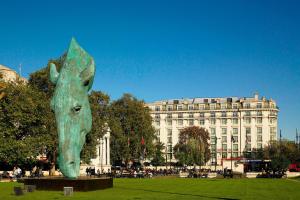 una statua di un cavallo in un parco con un edificio di London Marriott Hotel Park Lane a Londra