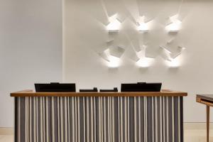 a reception desk with several lights on the wall at Le Méridien New York, Fifth Avenue in New York