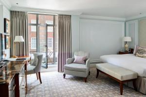 a bedroom with a bed and a desk and a chair at London Marriott Hotel Park Lane in London