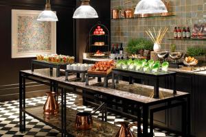 a buffet with several trays of food on display at London Marriott Hotel Park Lane in London