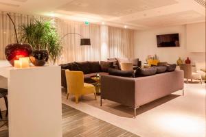 a living room with a couch and chairs at AC Hotel by Marriott Paris Le Bourget Airport in Le Bourget