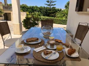 a glass table with food and drinks on it at B&B Villa Striari in Otranto