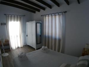 um quarto com uma cama e uma grande janela em CAN JAUME D’EN PEP MIQUEL em Sant Francesc Xavier