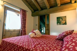 1 dormitorio con 1 cama con colcha roja en L'Or d'Echallogne - Chambre d'Hôtes en Arnad