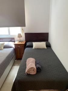 a bedroom with a bed with a blanket on it at Adosado tranquilo con piscina y vistas al mar in Puerto Marino