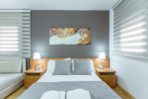 sypialnia z białym łóżkiem i kanapą w obiekcie Two bedroom TownHouse within 10min walk from Beach w Barcelonie